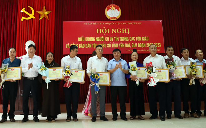 Chủ tịch Ủy ban MTTQ Việt Nam tỉnh Yên Bái Giàng A Tông (áo xanh) trao bằng khen và chúc mừng các cá nhân tại Hội nghị biểu dương người có uy tín trong các tôn giáo và đồng bào dân tộc thiểu số giai đoạn 2020 - 2023.