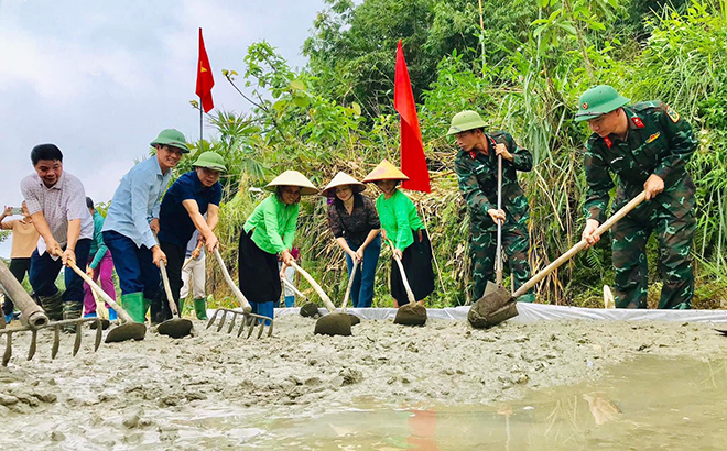 Cán bộ, chiến sĩ LLVT huyện Lục Yên giúp dân làm đường giao thông nông thôn tại xã Lâm Thượng.