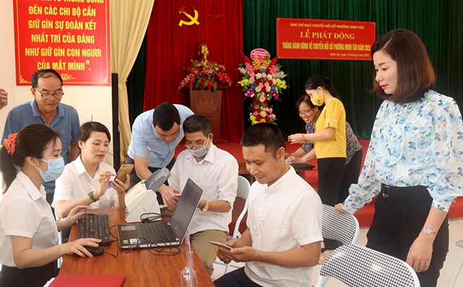 Cán bộ công chức phường Minh Tân hướng dẫn người dân cài đặt ứng dụng VNeID.