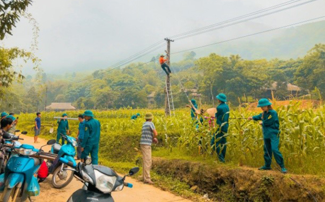 Lực lượng dân quân xã Phan Thanh giúp dân lắp đặt hệ thống điện chiếu sáng trong chương trình 