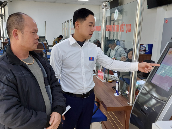 Cán bộ Bộ phận Phục vụ hành chính công huyện Mù Cang Chải hướng dẫn người dân thực hiện các giao dịch