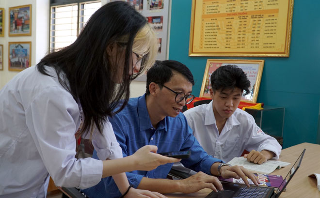 Thầy Đặng Trần Hà, giáo viên lớp chuyên Anh Trường THPT Chuyên Nguyễn Tất Thành tra cứu kết quả thi cùng học sinh nhà trường.