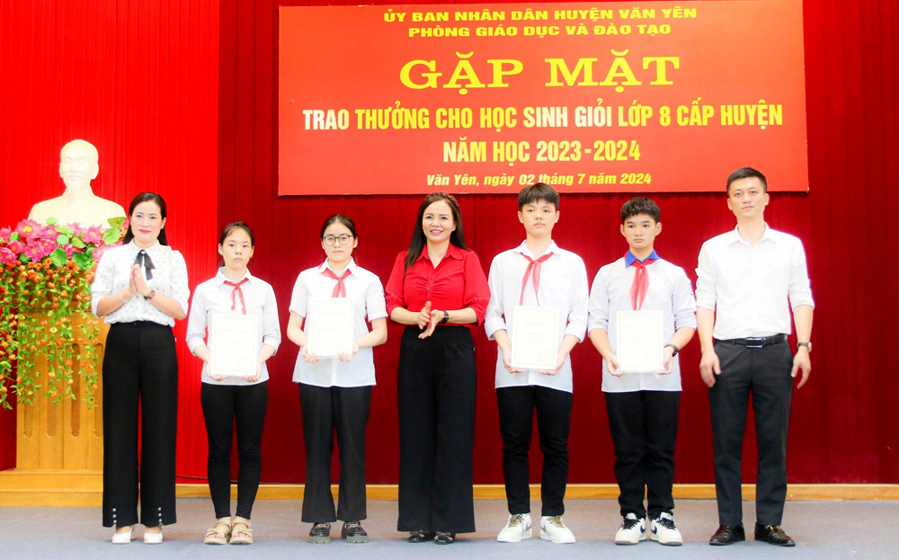 Lãnh đạo Phòng Giáo dục - Đào tạo huyện Văn Yên khen thưởng cho các em học sinh giỏi lớp 8.