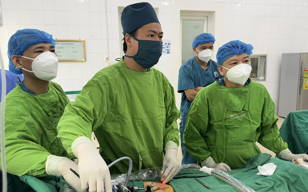 Bác sĩ chuyên khoa II Trần Quang Mạnh cùng kíp mổ thực hiện kỹ thuật phẫu thuật thoát vị bẹn bằng phương pháp nội soi cho bệnh nhi nam 5 tuổi.