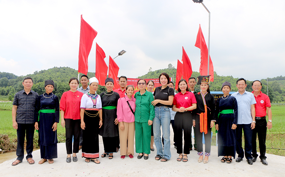 Lãnh đạo Hội Chữ thập đỏ thành phố Hà Nội, tỉnh Yên Bái cùng nhà tài trợ và bà con nhân dân thôn Đoàn Kết, xã Xuân Ái phấn khởi bên cây cầu dân sinh kiên cố.