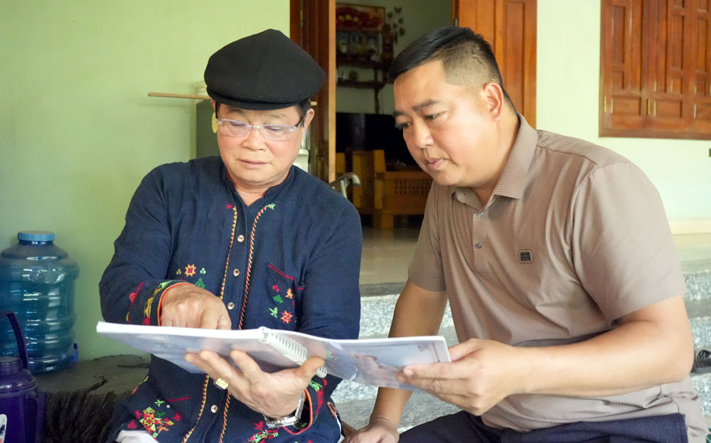 Ông Dương Kim Vượng (người bên trái) truyền dạy chữ Nôm Dao cho người dân. 

