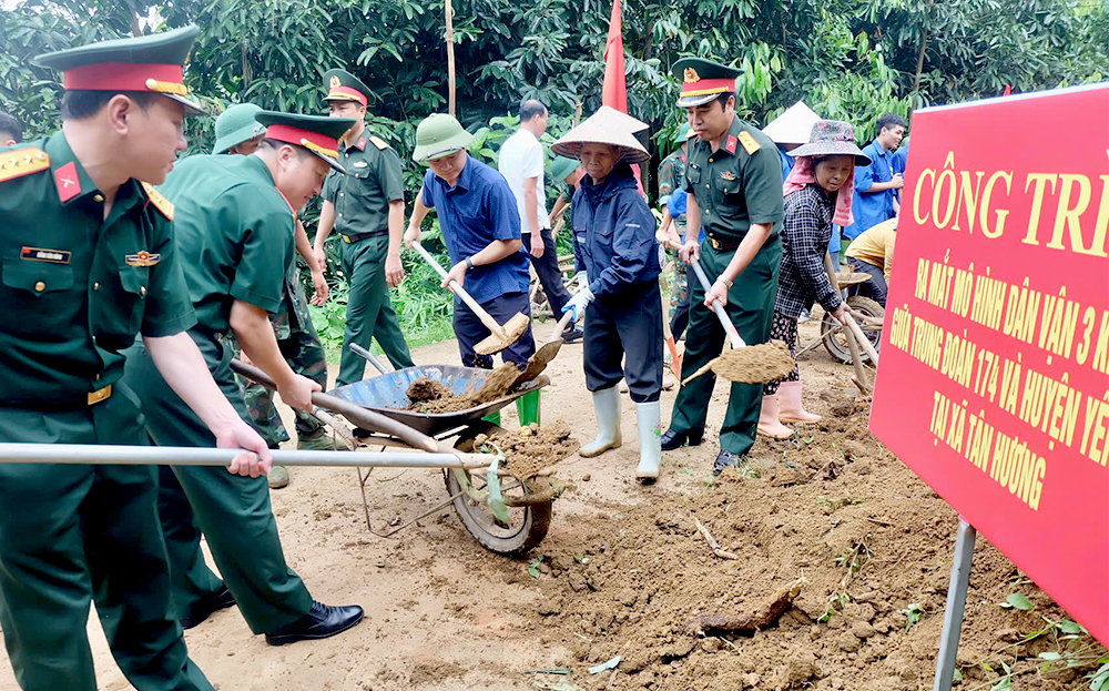 Các đồng chí lãnh đạo, cán bộ Huyện ủy Yên Bình, Trung đoàn 174 thực hiện mở rộng đường và dọn dẹp vệ sinh môi trường tại thôn Loan Thượng.