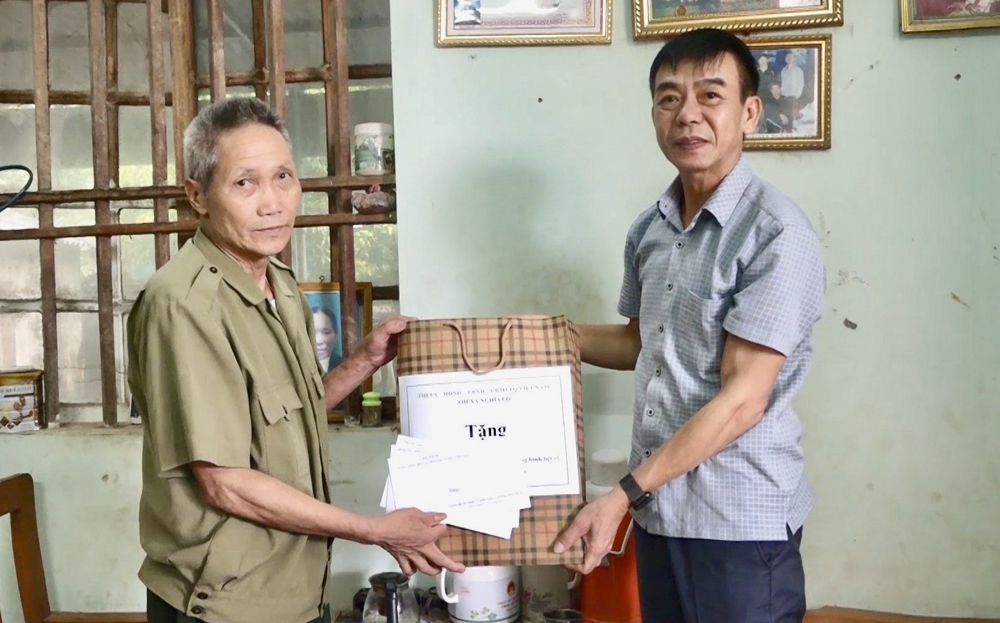 Đồng chí Hà Văn Nam - Phó Bí thư Thường trực Thị ủy, Chủ tịch HĐND thị xã Nghĩa Lộ (bên phải) tặng quà cho ông Hà Xuân Lái - bệnh binh 2/3 ở thôn Bản Lý, xã Thanh Lương nhân dịp 27/7/2024.