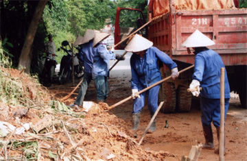 Công nhân Công ty xây dựng quản lý đường bộ II thu dọn đất sạt lở tại tổ 66, phường Nguyễn Thái Học (thành phố Yên Bái) do bị ảnh hưởng của cơn bão số 2 vừa qua.