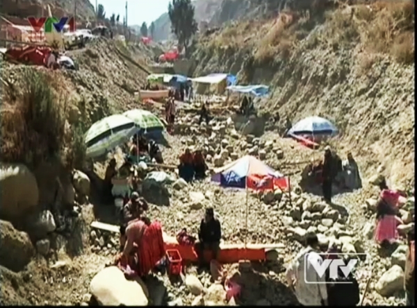 Người dân Bolivia xuống dưới lòng sông khô để lựa chọn những viên đá may mắn. (Ảnh: VTV News)