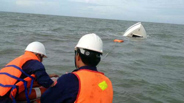 Nhân viên cứu hộ của Trung tâm Phối hợp và tìm kiếm cứu nạn khu vực 3 tìm cách kéo chiếc ca nô bị nạn vào bờ.
