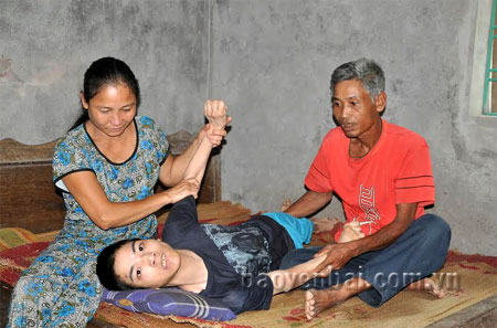 Vợ chồng bà Hằng và đứa con trai tật nguyền Nguyễn Tiến Độ.