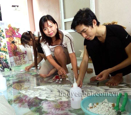 Chị Nguyễn Thị Nguyệt cùng các thợ trong xưởng chế tác tranh đá quý.
