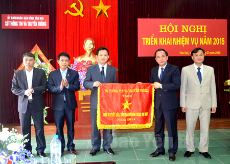 Đồng chí Tạ Văn Long - Phó Chủ tịch Thường trực UBND tỉnh (thứ hai, bên phải) trao cờ thi đua của Bộ Thông tin và Truyền thông cho Sở Thông tin và Truyền thông tỉnh Yên Bái năm 2014.