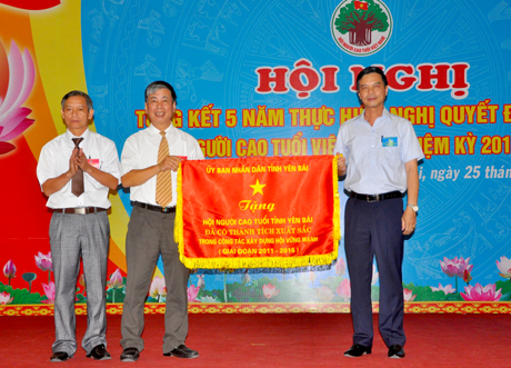 Đồng chí Dương Văn Tiến - Phó Chủ tịch UBND tỉnh trao Cờ thêu của UBND tỉnh tặng Hội NCT Yên Bái.