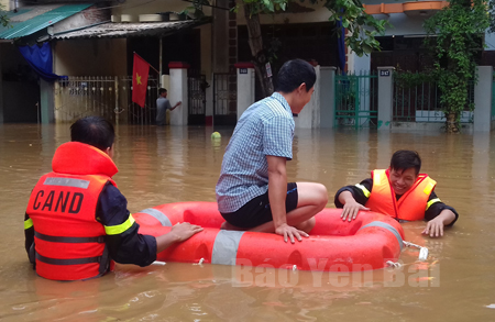 Lực lượng cảnh sát phòng cháy, chữa cháy - cứu nạn, cứu hộ Công an tỉnh dùng bè cứu sinh đưa người dân vùng lũ tới nơi an toàn.