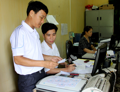 Cán bộ Phòng Dân tộc huyện kiểm tra thẻ BHYT cấp cho đối tượng người dân tộc thiểu số. Ảnh MQ