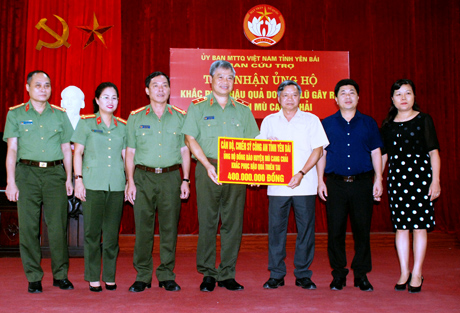 Thiếu tướng Đặng Trần Chiêu -  Giám đốc Công an tỉnh trao kinh phí hỗ trợ nhân dân huyện Mù Cang Chải cho lãnh đạo Ủy ban Mặt trận Tổ quốc tỉnh.
