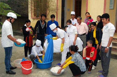 Cán bộ y tế xã Châu Quế Hạ hướng dẫn người dân ngâm tẩm màn chống muỗi.
