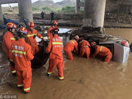 Lực lượng cứu hộ tìm kiếm nạn nhân trong chiếc xe chìm trong nước lụt.