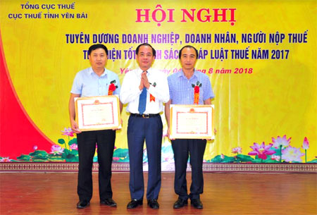 Ông Nguyễn Thanh Hải - Phó Tổng giám đốc Công ty cổ phần Thủy điện Thác Bà (bên phải) đại diện cho Công ty nhận bằng khen của Bộ Tài chính về thành tích chấp hành tốt chính sách pháp luật thuế năm 2017.