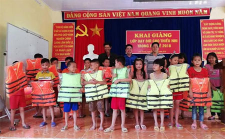 Thanh thiếu nhi được hỗ trợ áo phao trong quá trình tham gia lớp học bơi miễn phí.