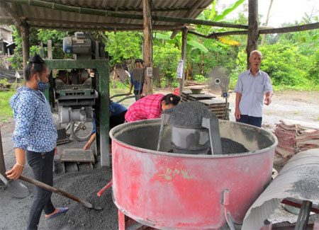 Ông Nguyễn Hữu Lưu trao đổi với công nhân trong quá trình sản xuất gạch bê tông.