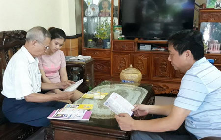 Cán bộ BHXH huyện Trấn Yên cùng đại lý thu bảo hiểm thị trấn Cổ Phúc tuyên truyền chính sách BHXH tự nguyện đến người dân.