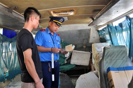 Cán bộ thanh tra giao thông kiểm tra phương tiện vận tải hành khách tuyến cố định.