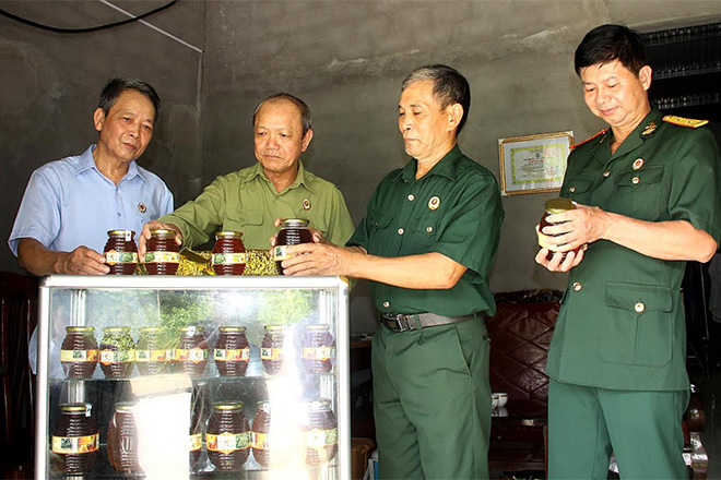 Thương binh Bùi Văn Đốc (thứ hai bên phải) giới thiệu sản phẩm mật ong với lãnh đạo Hội CCB thành phố Yên Bái.