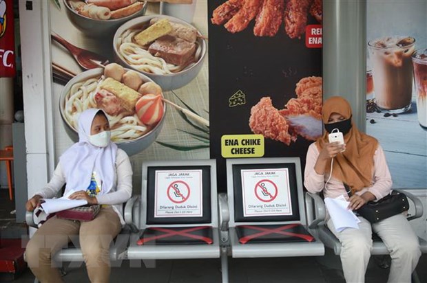 Người dân đeo khẩu trang và thực hiện giãn cách xã hội phòng lây nhiễm COVID-19 tại Jakarta, Indonesia.
