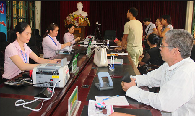 Cán bộ Ngân hàng Chính sách xã hội thành phố Yên Bái giải quyết vốn vay tại điểm giao dịch phường Đồng Tâm.