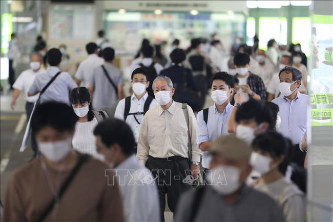 Người dân đeo khẩu trang phòng dịch COVID-19 tại nhà ga Shinjuku ở Tokyo, Nhật Bản.