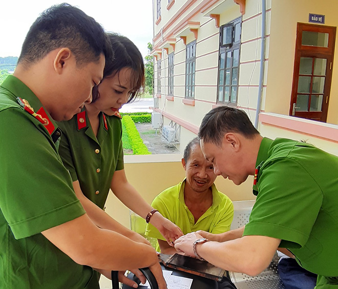 Cán bộ chiến sĩ công an thuộc Trung tâm Phục vụ hành chính công tỉnh hỗ trợ người khó khăn thực hiện thủ tục cấp chứng minh nhân dân.