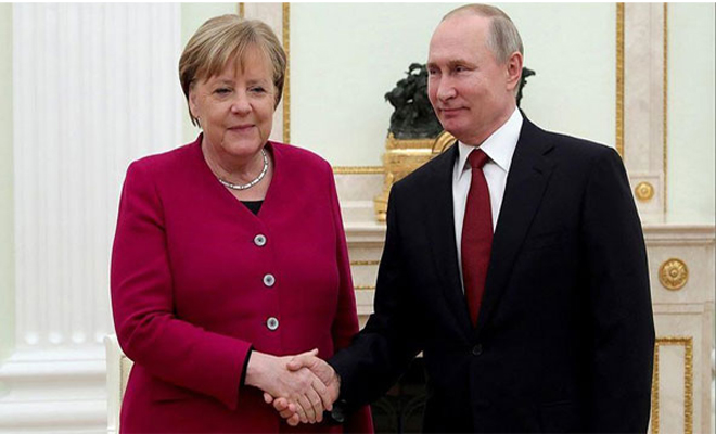 Thủ tướng Merkel (trái) bắt tay Tổng thống Putin. Ảnh: Anadolu