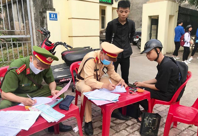 Cán bộ Đội Cảnh sát giao thông - Trật tự, Công an huyện Trấn Yên lập biên bản xử phạt vi phạm hành chính đối với trường hợp học sinh vi phạm Luật Giao thông đường bộ.
