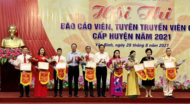 Lãnh đạo Ban Tuyên giáo Tỉnh ủy và Huyện ủy Yên Bình trao cờ lưu niệm cho các thí sinh tham gia Hội thi.