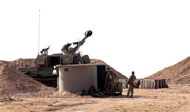 Binh sĩ thuộc quân đoàn pháo binh Israel cùng các trang thiết bị quân sự tại khu vực biên giới với Dải Gaza, ngày 7-8-2022.