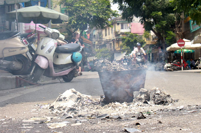 Người dân đốt vàng mã ngay trên đường, cạnh những chiếc xe máy gây nguy cơ cháy nổ và ô nhiễm môi trường.