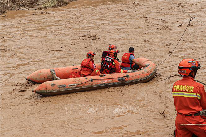 Nhân viên cứu hộ sơ tán người dân khỏi các khu vực ngập lụt ở tỉnh Cam Túc, Trung Quốc, ngày 16/7/2022.