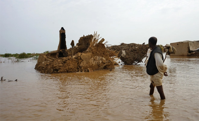 Một người dân lội qua khu vực bị ngập lụt ở Kassala, Sudan, ngày 18/8/2022.