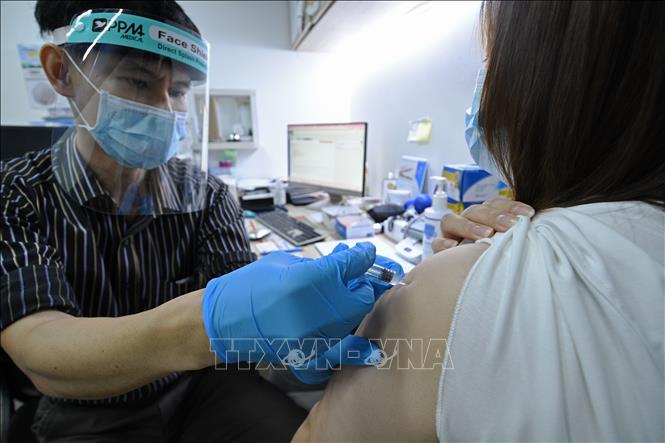 Nhân viên y tế tiêm vaccine phòng COVID-19 cho người dân tại Singapore.