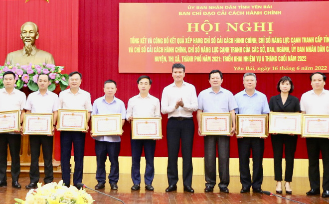 Chairman of the Yen Bai provincial People’s Committee Tran Huy Tuan presents certificates of merits to collectives with outstanding performance in administrative reform and business climate improvement in 2021.