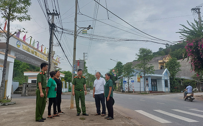 Cán bộ Công an phường Yên Thịnh trao đổi về cách sử dụng và bảo trì mắt camera an ninh tại địa bàn dân cư.