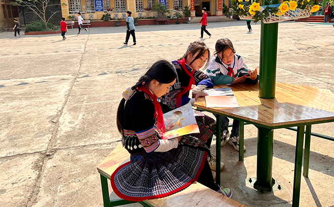 Các em học sinh Trường TH&THCS thị trấn Mù Cang Chải đọc sách trên sân trường.