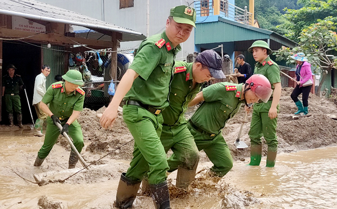 Cán bộ, chiến sỹ Công an huyện Mù Cang Chải giúp nhân dân xã Hồ Bốn dọn dẹp bùn đất, khắc phục hậu quả  trận mưa lũ đêm 5/8 vừa qua.