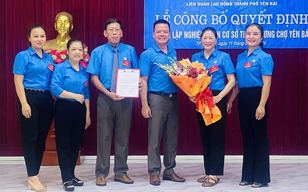 Lãnh đạo Liên đoàn lao động thành phố Yên Bái trao quyết định và tặng hoa chúc mừng Nghiệp đoàn cơ sở tiểu thương chợ Yên Bái.