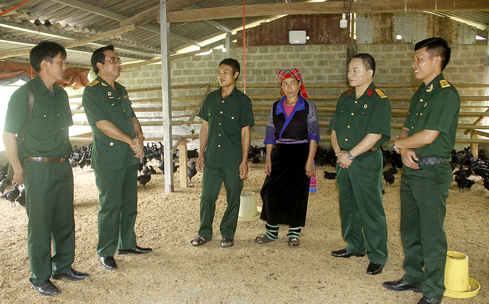 Vợ chồng cựu chiến binh Hờ A Rùa (giữa) chia sẻ kinh nghiệm nuôi gà đen với lãnh đạo Hội CCB tỉnh và huyện Mù Cang Chải.