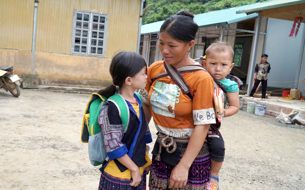 Nhờ nâng cao chất lượng dân số, trẻ em vùng cao được chăm lo đầy đủ.
(Trong ảnh: Một bà mẹ tại xã Hồ Bốn, huyện Mù Cang Chải đưa con đến trường).