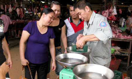 Kiểm định phương tiện đo là cân thông dụng dùng trong kinh doanh tại chợ Yên Bình. (Ảnh Thanh Sơn)